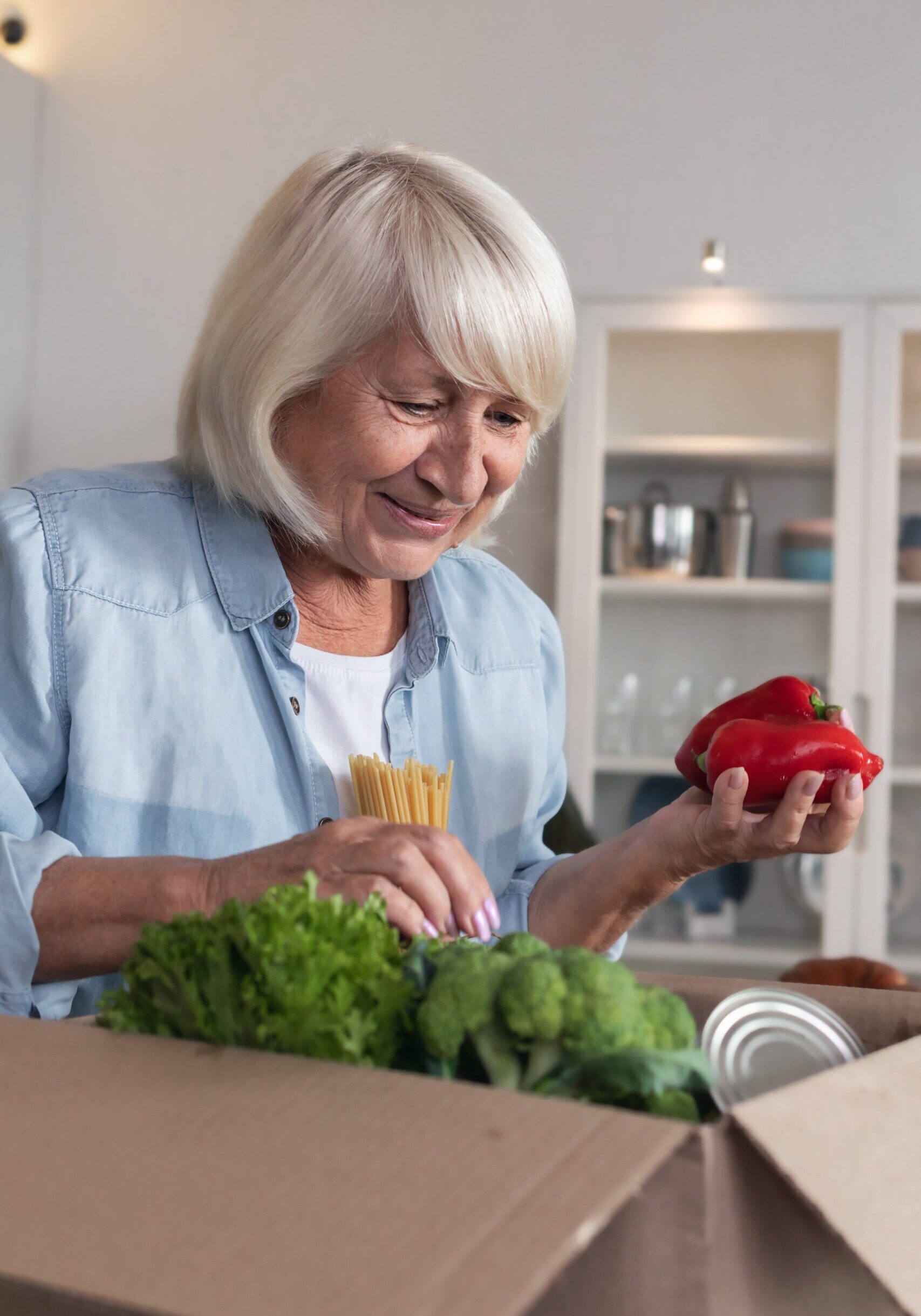Food delivery or donation concept. Happy elderly woman received a box of food from volunteers Food delivery or donation concept. Happy elderly woman received a box of food from volunteers